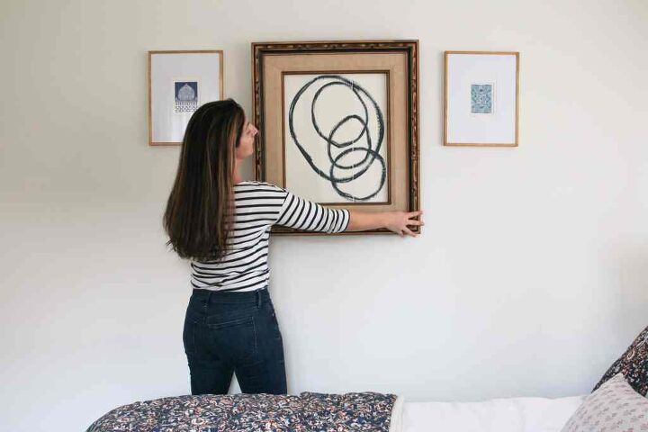 4 diy home decor projects you can do in one day, Woman hanging diy abstract art on bedroom wall