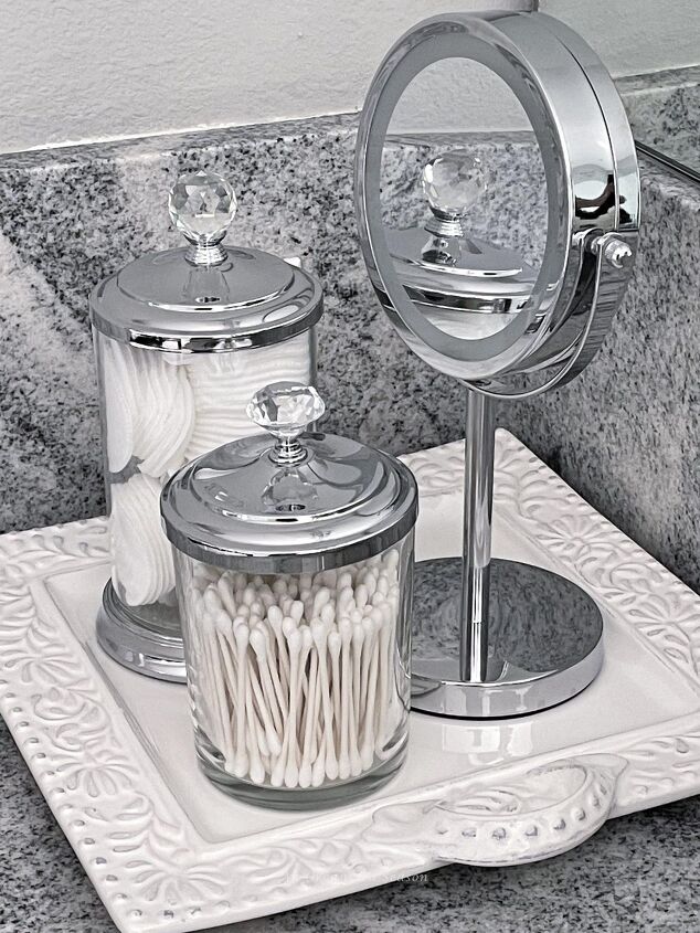 15 awesome storage solutions for your bathroom, Clear canisters and a mirror on a tray on bathroom counter