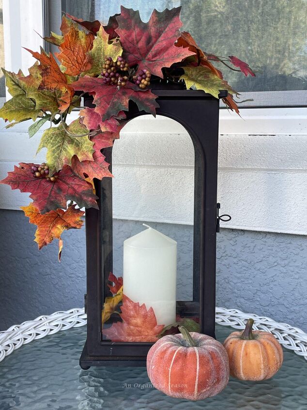 budget decorating ideas for an amazing fall porch, A brown metal lantern with a candle decorated with fall leaves Reuse this old lantern for a Budget decorating ideas for fall porch