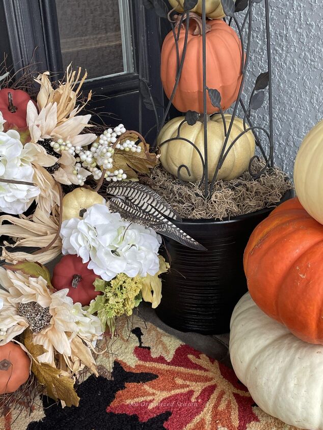 budget decorating ideas for an amazing fall porch, A rug pumpkins and a wreath used to decorate a front porch