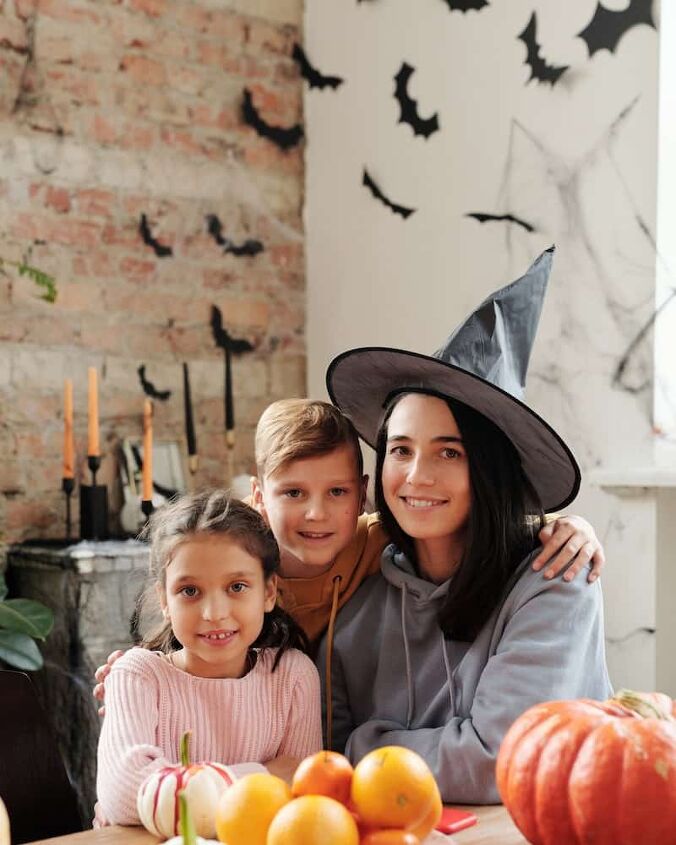 best ways to save money on halloween, a family with homemade Halloween costumes sitting at the table