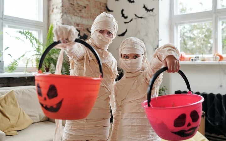 best ways to save money on halloween, two children dressed as mummies for Halloween