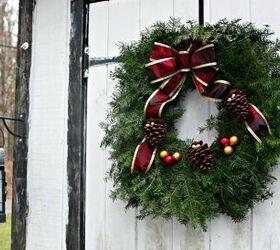how to have a greener christmas that s more sustainable, a Christmas wreath hanging on a white door