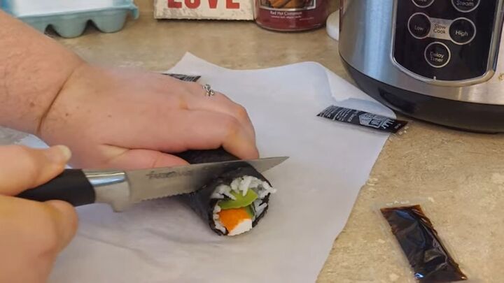 easy budget sushi recipes how to make cheap sushi at home, Cutting the homemade sushi rolls