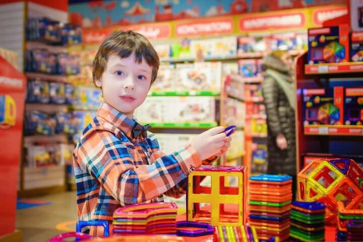 how to save money on toys, a boy in a toy store