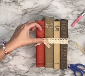 6 cute diy book decor ideas using books from dollar tree, Hot gluing the bow
