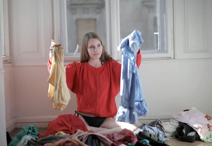 home dry cleaning solutions for delicates, a woman holding clothes that need to be cleaned