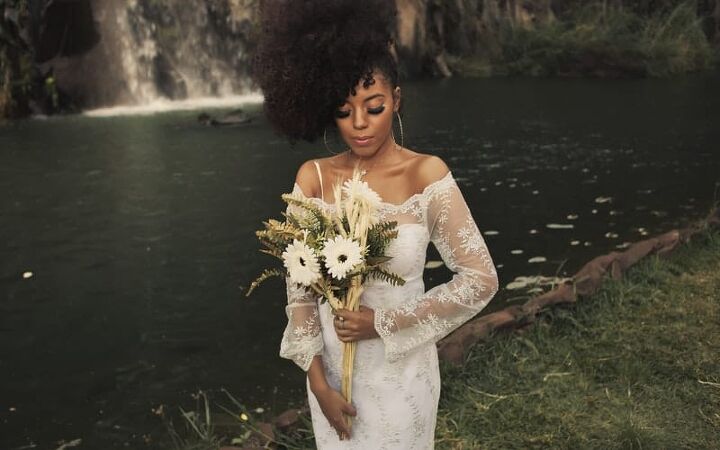 fall wedding ideas on a budget, a woman wearing a long sleeve wedding dress holding cream colored flowers