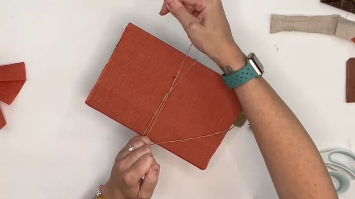 7 crafty ways to use dollar tree fabric this fall, Wrapping the fabric covered books with twine