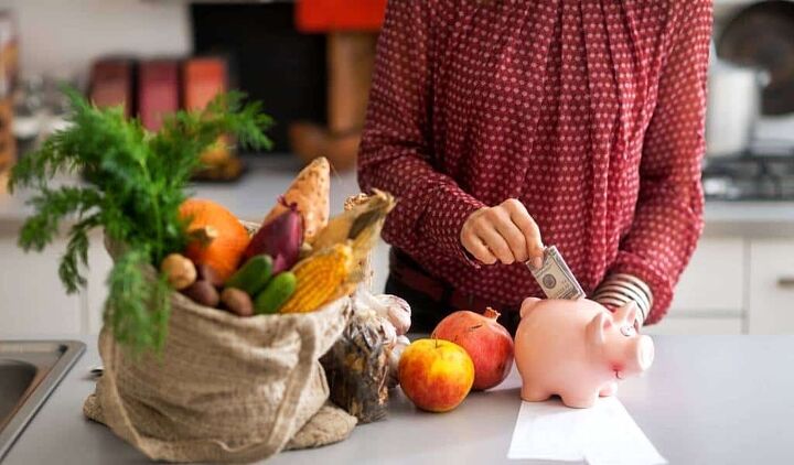 budget grocery list the best cheapest foods for tight budgets, woman putting money into a piggy bank with a bag of grocery shopping