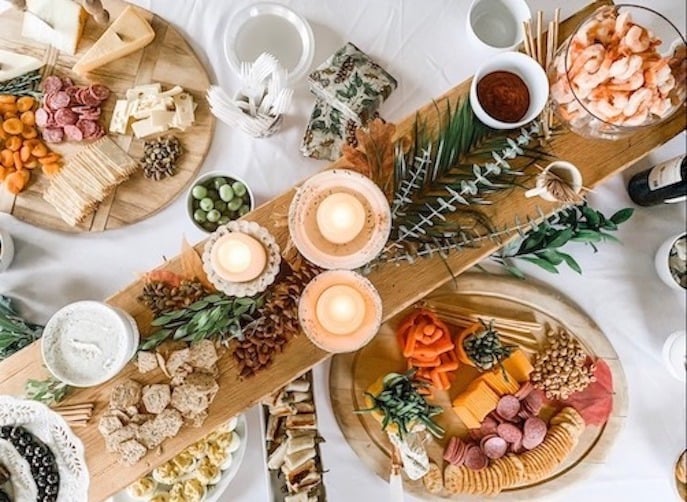 holiday entertaining on a budget, photo of a charcuterie table with cheese crackers nuts olive shrimp and more to entertain on a budget