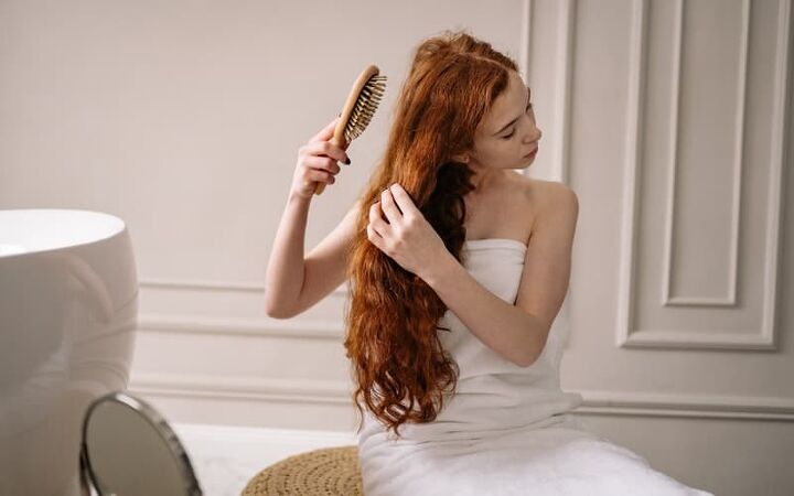 home remedies for split ends, a woman in a towel brushing her hair