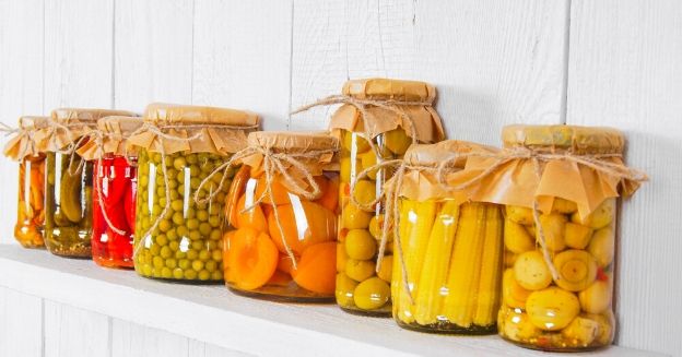 55 best cheap foods to buy when you re broke, line of glass jars filled with homemade preserved vegetables and fruits