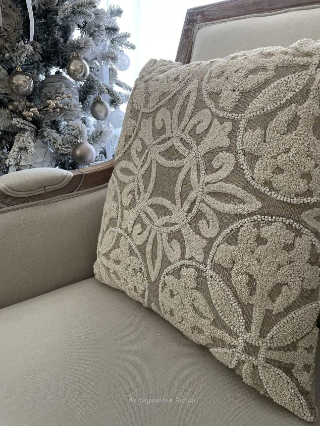 seven ways to decorate for christmas on a budget, An embroidered pillow cover in cream white and champagne