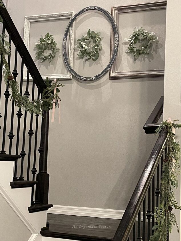 seven ways to decorate for christmas on a budget, Three empty picture frames hanging on a wall with a wreath inside each one is a good way to decorate for Christmas on a budget