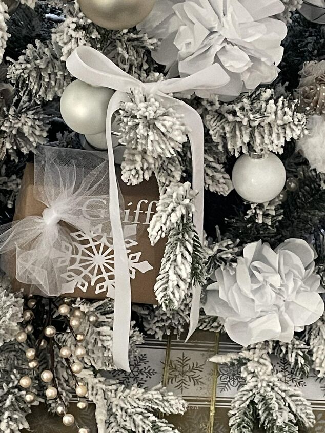 seven ways to decorate for christmas on a budget, A Christmas tree with white paper flowers white velvet bows and small wrapped packages