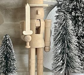 seven ways to decorate for christmas on a budget, A wooden nutcracker surrounded by bottlebrush trees