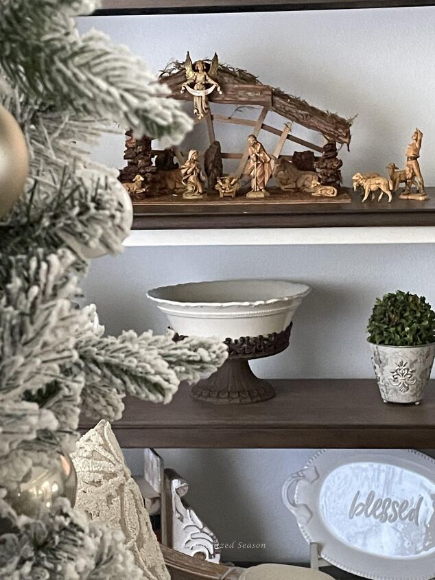 seven ways to decorate for christmas on a budget, A book shelf with a nativity set displayed on it