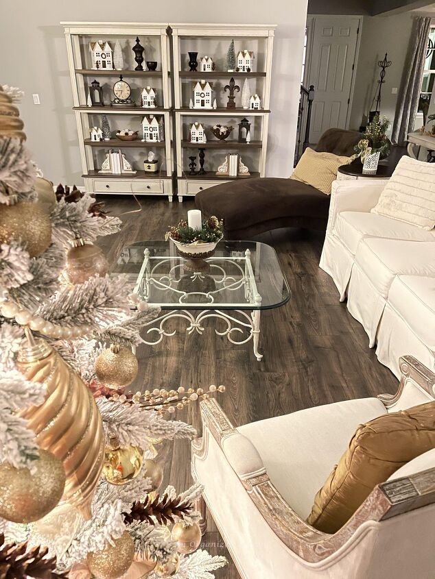 how to get organized for holiday entertaining, A living room bookshelf decorated with a Christmas Village will help get you organized for holiday entertaining