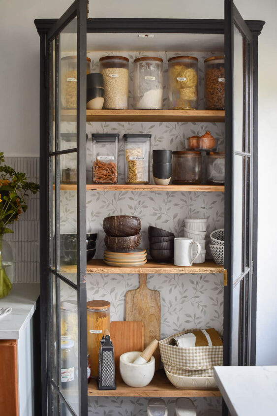 30 affordable pantry organization storage ideas you need to see, Pantry Organization Ideas Vintage cabinet is refinished with paint and wallpaper Clear containers organize dry goods along with bowls mugs and cutting boards