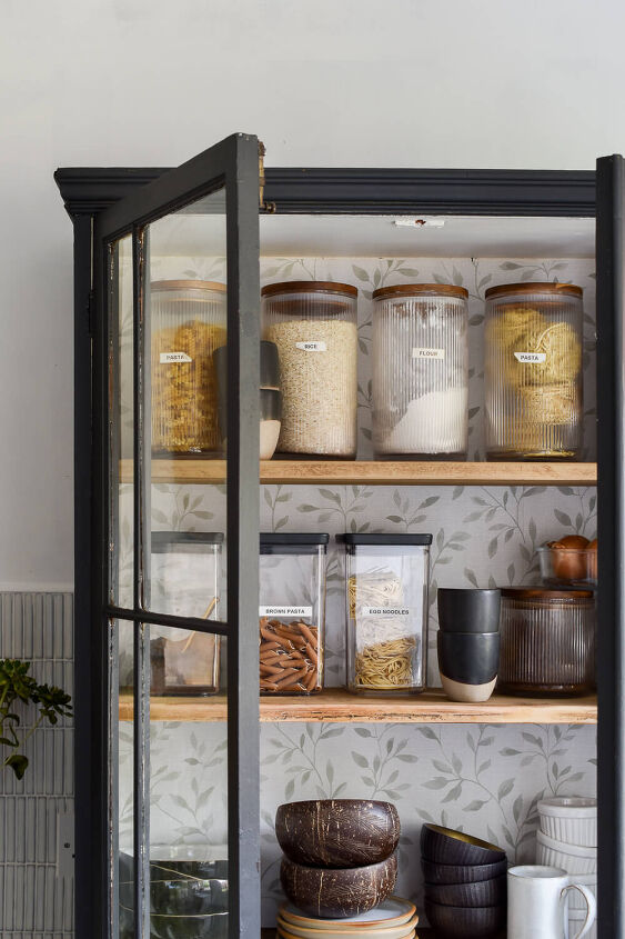 30 affordable pantry organization storage ideas you need to see, Pantry Organization Ideas Vintage cabinet is refinished with paint and wallpaper Clear containers organize dry goods along with bowls mugs