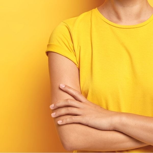 14 amazing benefits of decluttering your home get started, Lady in yellow tshirt folding her arms with a yellow background