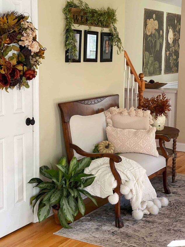 7 easy ways to make faux flowers look real, Front entry hall decorated for fall with antique bench black picture frames and a welcome sign plus a fall wreath and houseplants rustic farmhouse fall home tour 2021 front entry