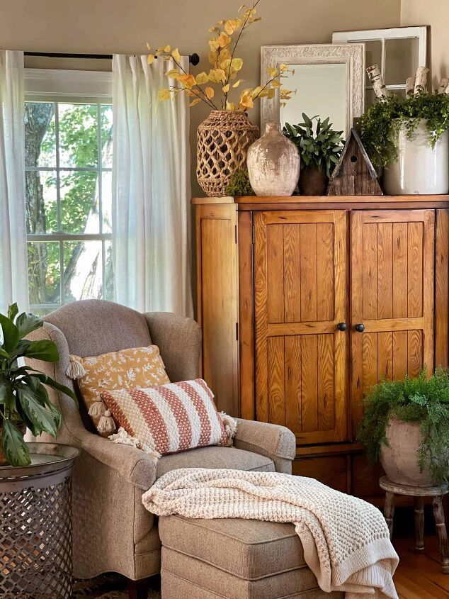 7 easy ways to make faux flowers look real, cozy reading nook with throw pillows and houseplants decorated for fall rustic farmhouse fall hone tour 2021