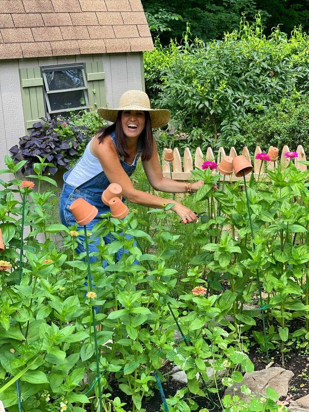 7 easy ways to make faux flowers look real, Home and Garden Blogger Stacy Ling cutting zinnia flowers in her cottage garden with wood picket fence in front of garden shed