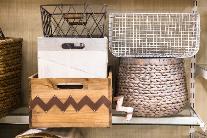 how to declutter your kitchen, baskets and bins piled on top of each other on a shelf
