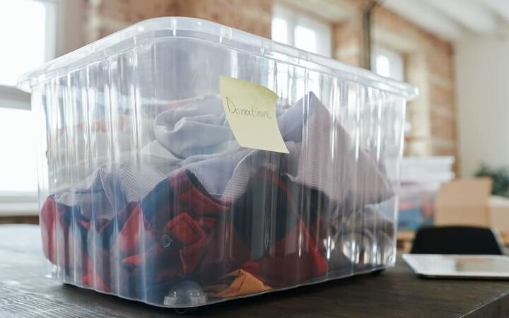the benefits of decluttering your possessions, a plastic tub full of clothets