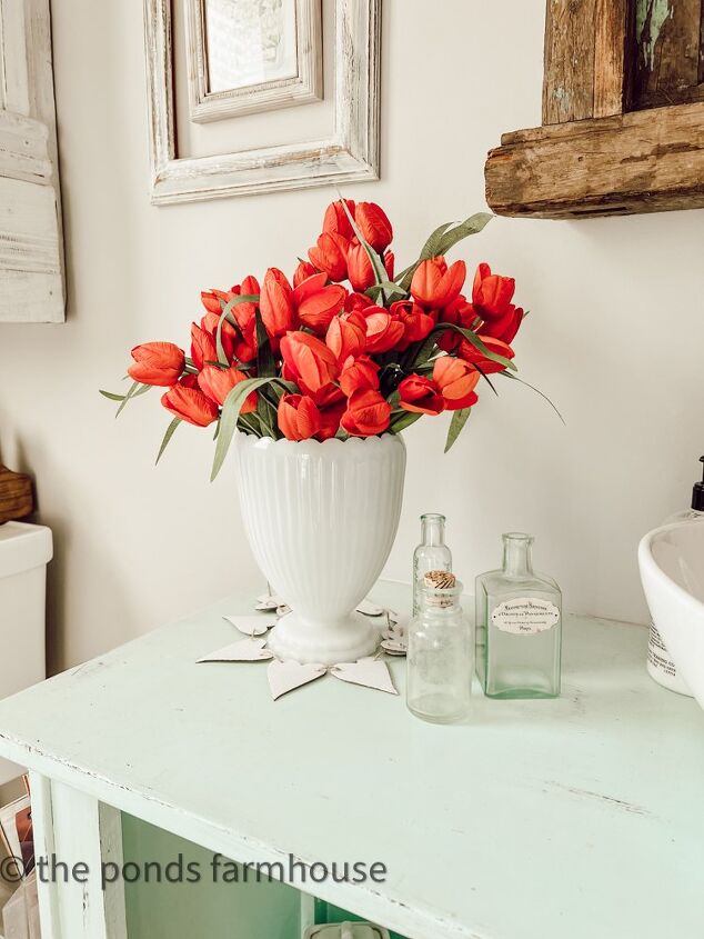 the best thrifted valentine s decor ideas, Milk Glass Vase filled with red tulips and old green bottles for Valentine s Decor Ideas