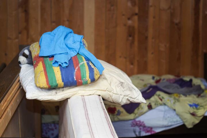 what to do with old pillows, Disassembled bed with a heap of crumpled clothing indoor shot