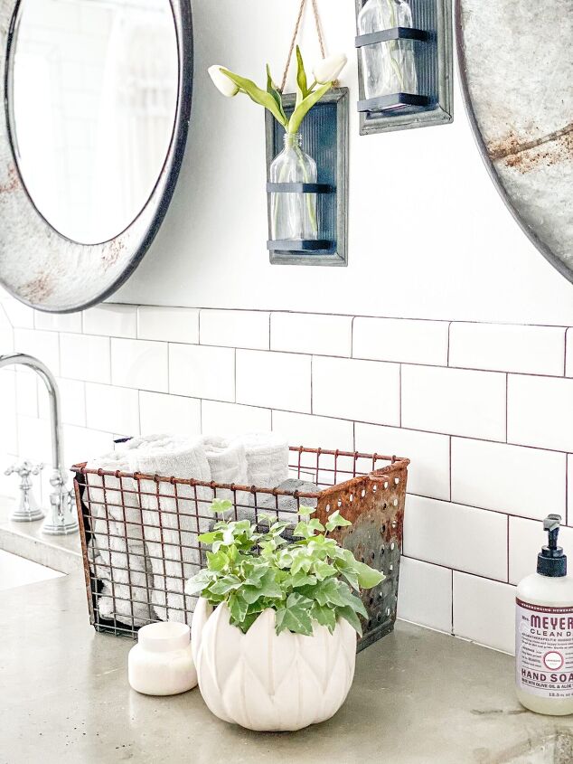 simple decor series how to decorate a small bathroom on a budget, Vintage locker basket with neatly rolled up white handtowels sit on the cocrete countertop beside the chrome faucet sink