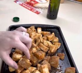 the best copycat fast food recipes you need to try, A pan of homemade roasted Taco Bell Fiesta potatoes with someone picking one up