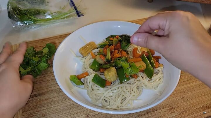 extreme budget meal plan simple and delicious meals under 25 dollars, Topping stir fried vegetables and noodles with fresh cilantro