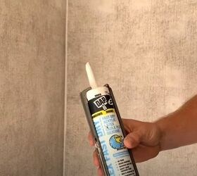 unleash your rv s beauty learn how to paint rv walls like a pro, Holding a tube of acrylic caulk