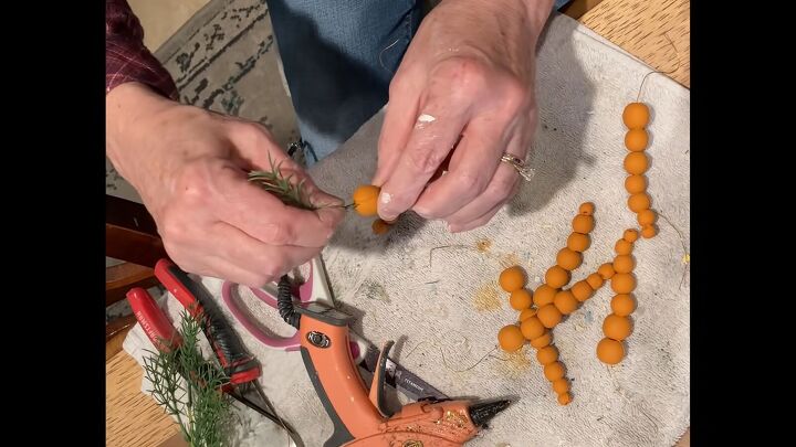 diy easter decor how to make affordable stylish decorations, Stringing orange beads onto florist wire