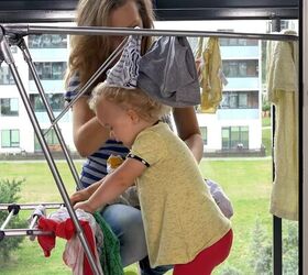 frugal living tips, Woman hanging laundry out with baby