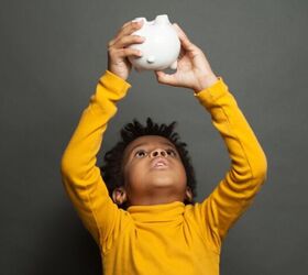 3 reasons frugal parents should let their kids earn an allowance, Child holding up a piggy bank